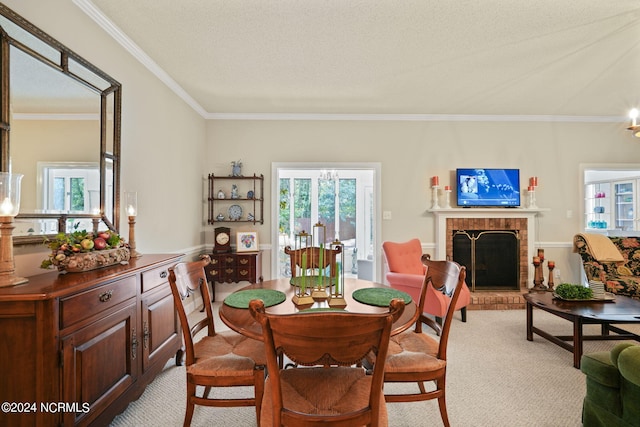 dining room with light carpet, ornamental molding, a textured ceiling, and a fireplace