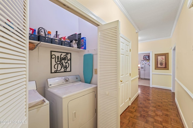 laundry room featuring crown molding, a textured ceiling, laundry area, independent washer and dryer, and baseboards