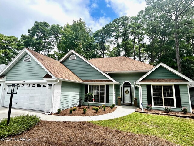 view of front of home featuring a front yard and a garage