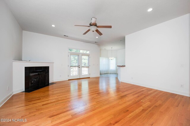 unfurnished living room with light wood-type flooring, ceiling fan, and a tile fireplace