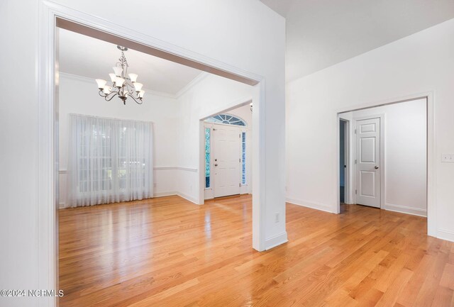 interior space featuring ornamental molding, a chandelier, and light hardwood / wood-style floors