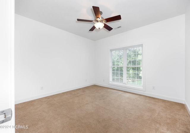 carpeted spare room featuring ceiling fan