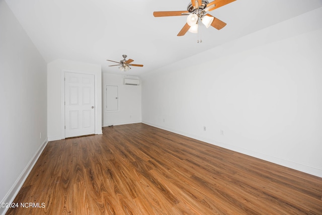 unfurnished room with a wall unit AC, lofted ceiling, ceiling fan, and hardwood / wood-style flooring