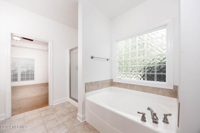 bathroom with ceiling fan, separate shower and tub, and tile patterned floors