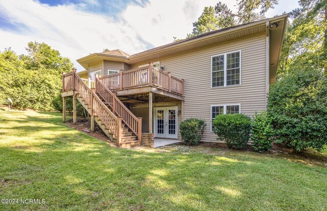 back of house with a wooden deck, a yard, and french doors