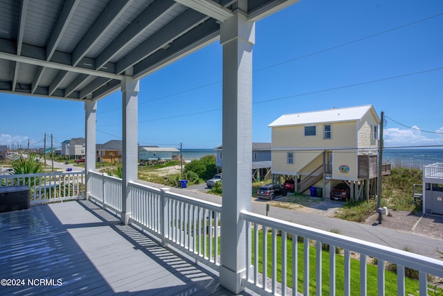 wooden terrace featuring a porch and a water view