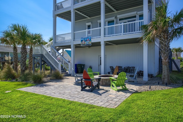 back of house featuring a fire pit, stairway, a patio area, and a lawn