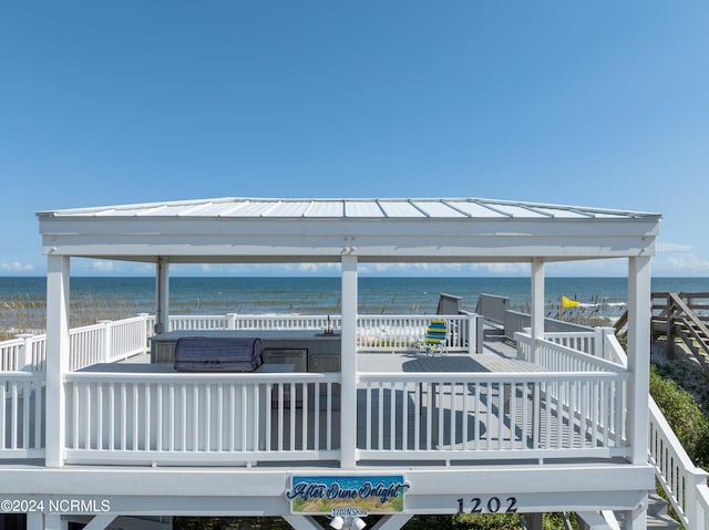 exterior space with a deck with water view and a jacuzzi