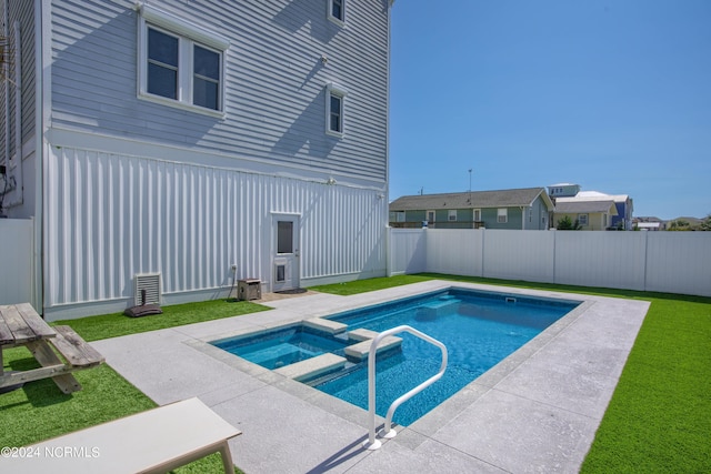 view of pool with a pool with connected hot tub, a fenced backyard, a yard, and a patio