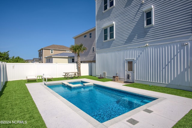 view of pool featuring a lawn, a patio area, a fenced backyard, and a pool with connected hot tub