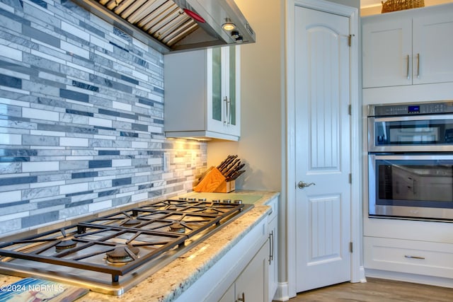 kitchen featuring appliances with stainless steel finishes, white cabinets, and glass insert cabinets