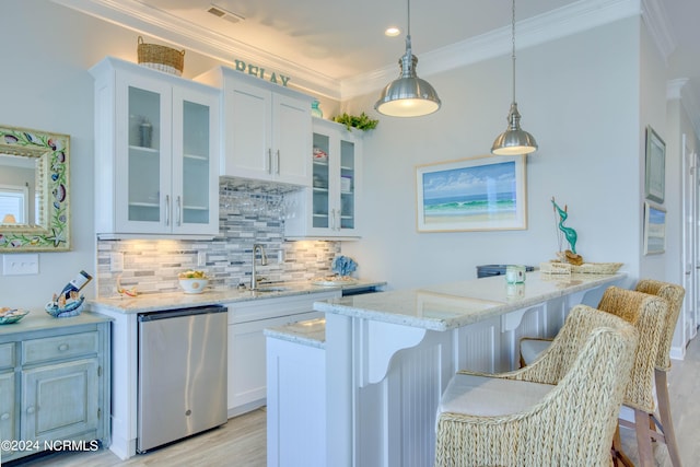 kitchen with light stone counters, white cabinets, and fridge