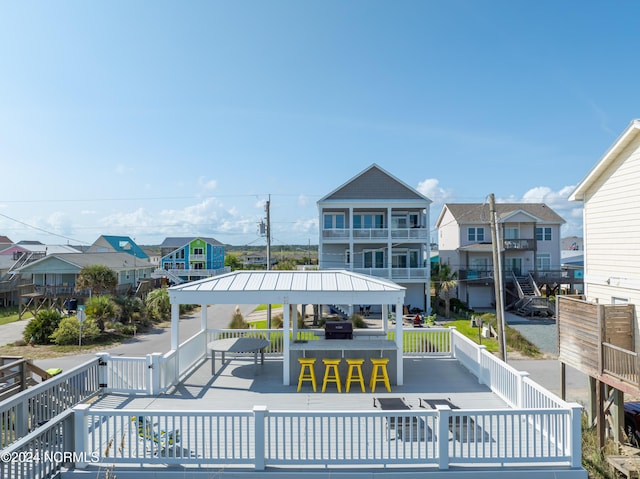 view of home's community with a deck, a residential view, outdoor dry bar, and a gazebo