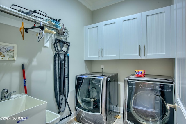 laundry area featuring cabinet space, washing machine and dryer, ornamental molding, and a sink