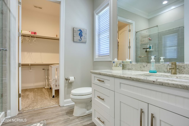 full bath with a shower stall, ornamental molding, a walk in closet, and vanity