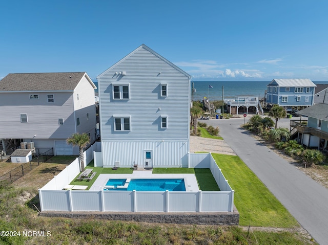 back of house featuring a patio area, a water view, a fenced backyard, and a fenced in pool