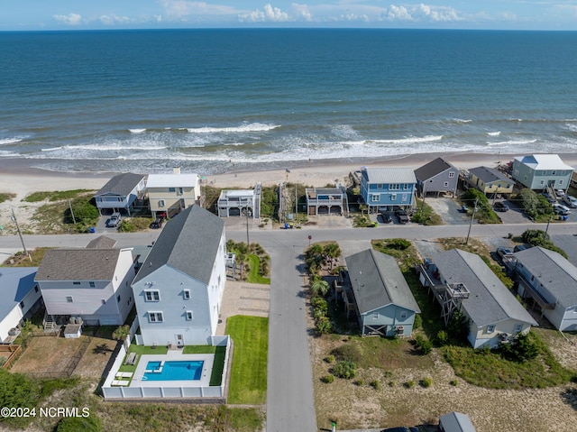 drone / aerial view featuring a beach view, a water view, and a residential view