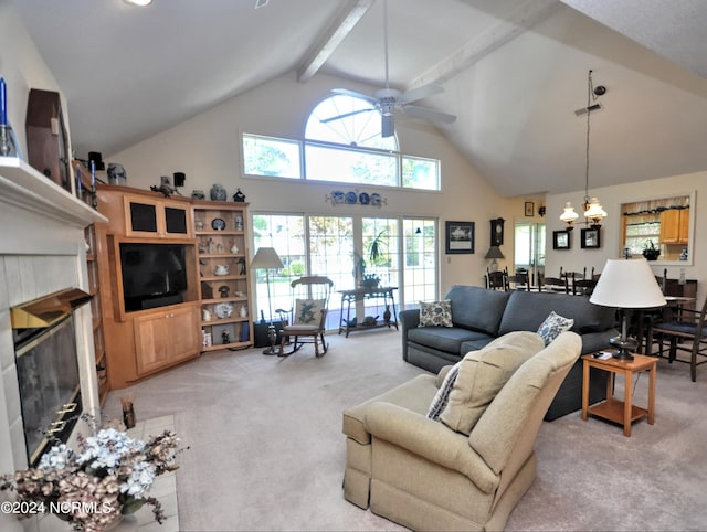 living area featuring beam ceiling, light colored carpet, a tiled fireplace, high vaulted ceiling, and ceiling fan with notable chandelier