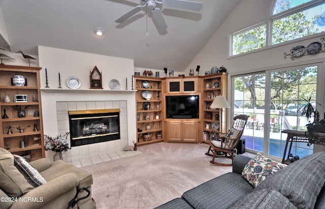 living area featuring light carpet, high vaulted ceiling, a ceiling fan, and a tiled fireplace