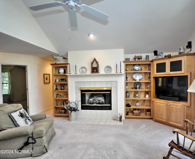 carpeted living room with lofted ceiling, ceiling fan, and a tile fireplace