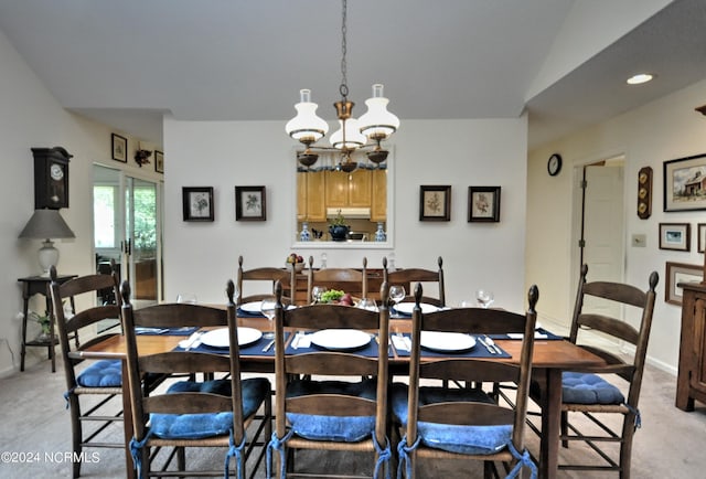 dining room featuring an inviting chandelier, baseboards, and light colored carpet