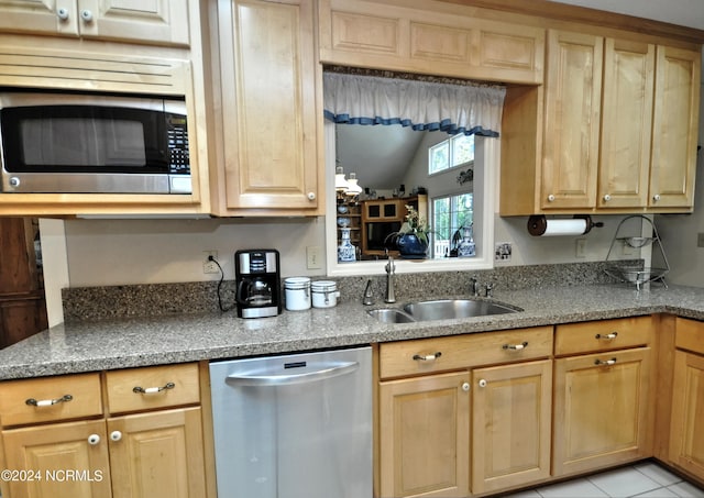 kitchen with lofted ceiling, appliances with stainless steel finishes, a sink, and light brown cabinets