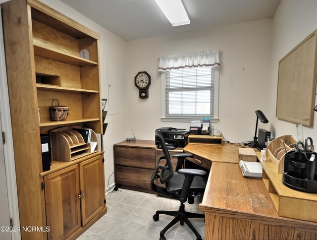 tiled home office featuring a textured ceiling