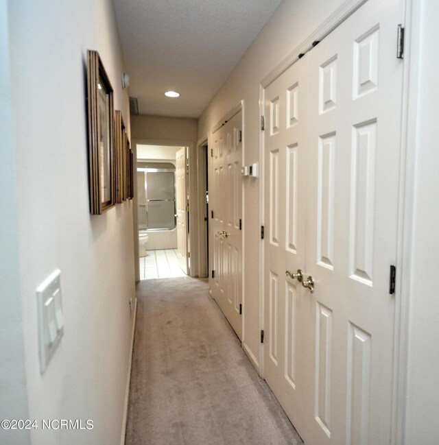 corridor featuring light colored carpet