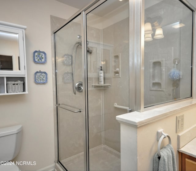 bathroom with a stall shower, vanity, and toilet