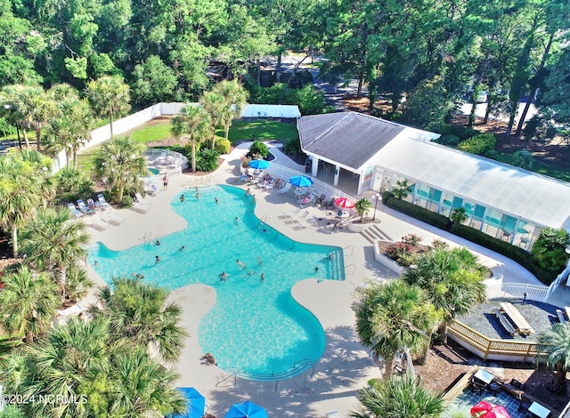 community pool with a patio and fence