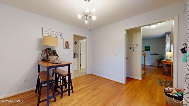 dining space featuring light hardwood / wood-style flooring and an inviting chandelier