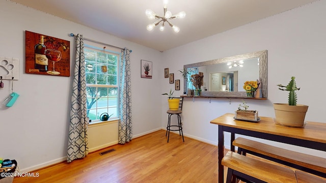 dining room with hardwood / wood-style flooring and a notable chandelier