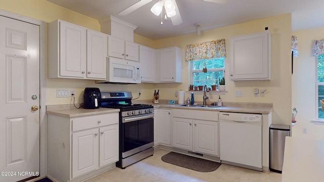 kitchen with ceiling fan, sink, white appliances, and white cabinetry