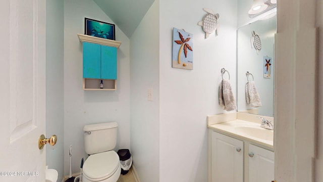 bathroom featuring lofted ceiling, toilet, and vanity