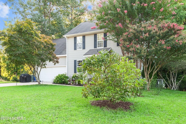 colonial home featuring a garage and a front yard