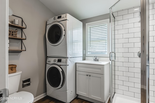 washroom with dark hardwood / wood-style floors, sink, and stacked washer / dryer