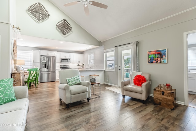 living room with dark wood-type flooring, ceiling fan, high vaulted ceiling, and ornamental molding