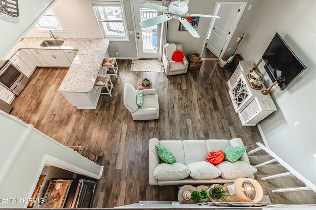 interior space with dark wood-type flooring, ceiling fan, sink, and a high ceiling