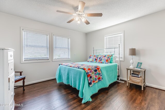 bedroom with dark wood-type flooring, ceiling fan, and a textured ceiling