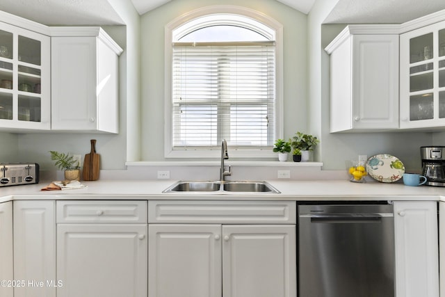 kitchen featuring a sink, white cabinets, stainless steel dishwasher, and light countertops