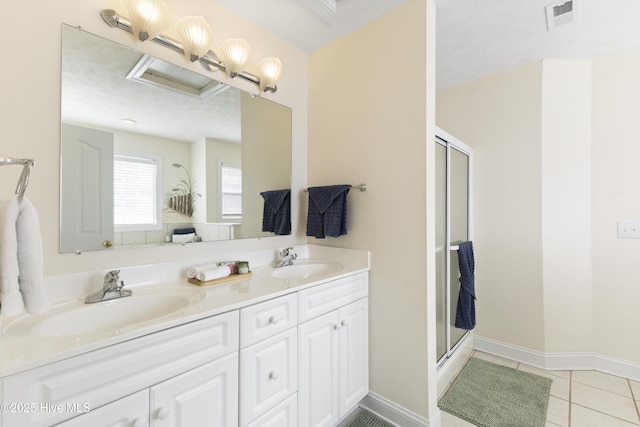 bathroom with a stall shower, a sink, visible vents, and tile patterned floors