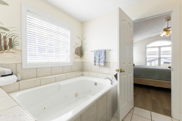 bathroom with a ceiling fan, ensuite bath, a tub with jets, and tile patterned flooring