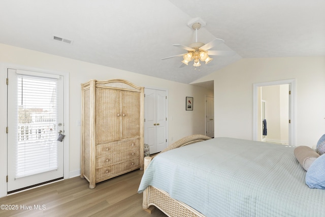 bedroom featuring lofted ceiling, ceiling fan, visible vents, access to exterior, and light wood-style floors