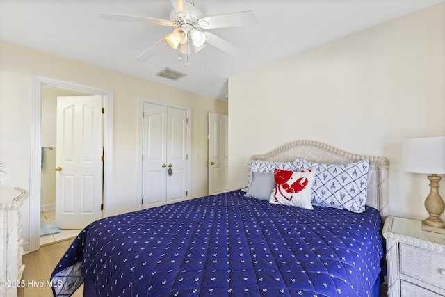 bedroom featuring a closet, visible vents, a ceiling fan, and wood finished floors