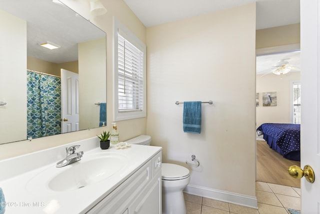 ensuite bathroom with toilet, ensuite bathroom, a wealth of natural light, and tile patterned floors