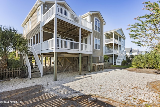 back of house featuring stairs and driveway