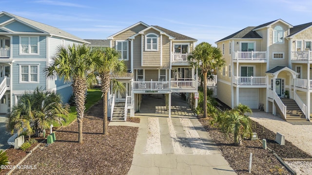 coastal home featuring a carport, driveway, and stairs