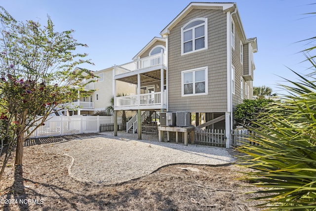 rear view of property with central AC unit, stairway, and fence