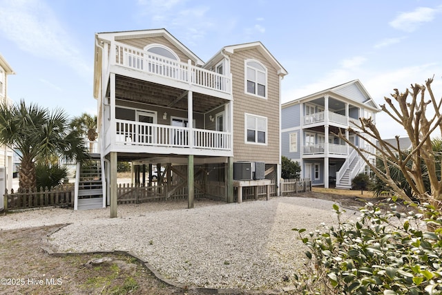 back of house featuring a carport, stairway, and central air condition unit