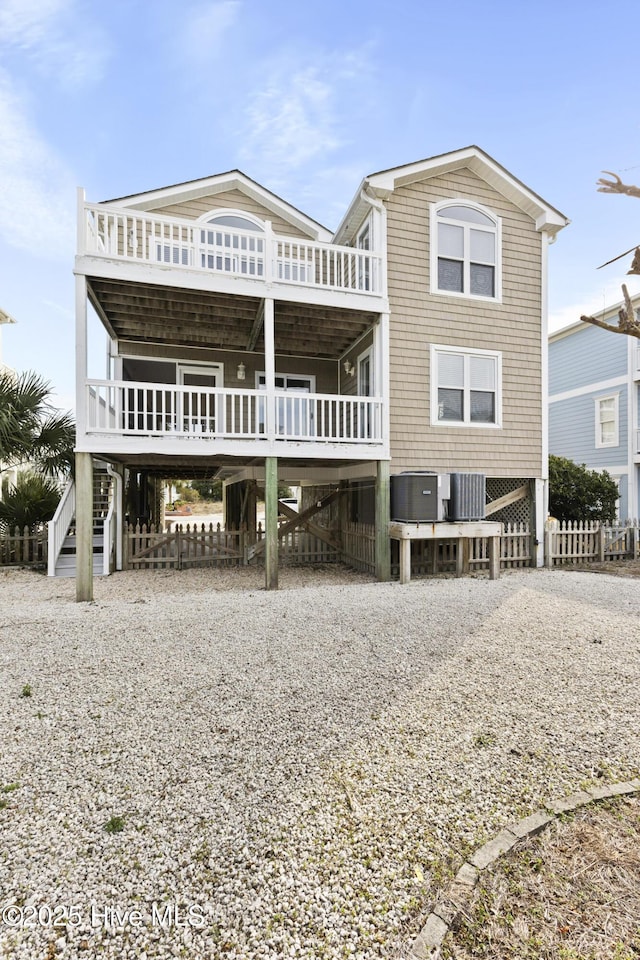 back of property with a carport, stairway, and cooling unit